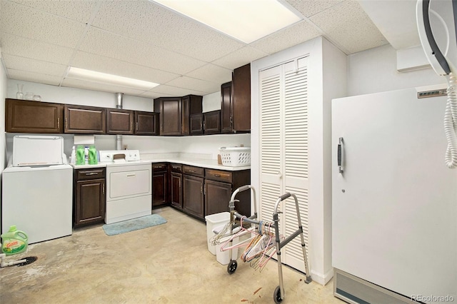 kitchen featuring freestanding refrigerator, independent washer and dryer, and a drop ceiling
