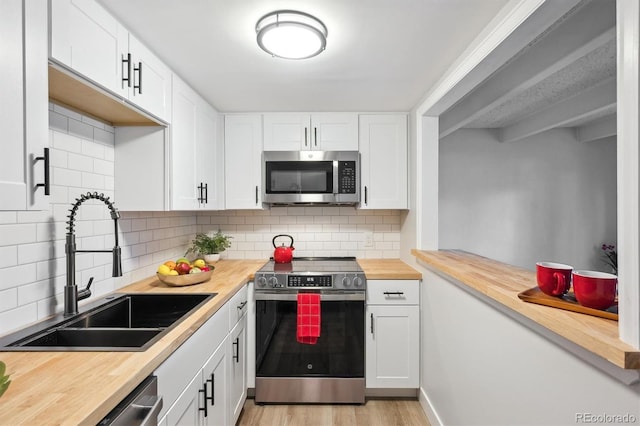 9700 E Iliff Ave Unit A3, Denver, CO 80231 - kitchen featuring appliances with stainless steel finishes, wood counters, light wood finished floors, and white cabinetry