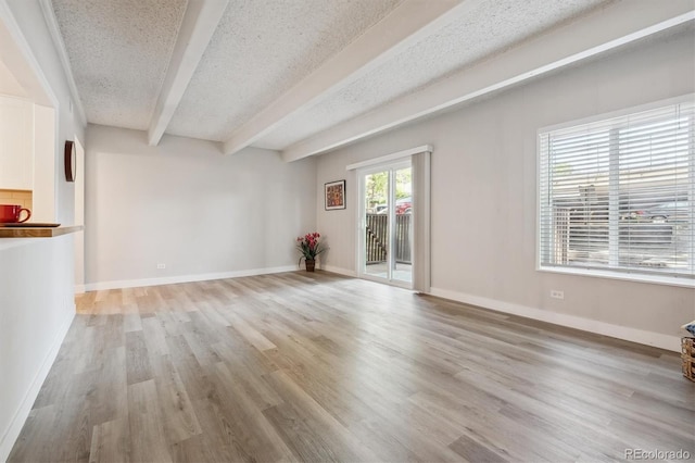 9700 E Iliff Ave Unit A3, Denver, CO 80231 - unfurnished living room with beamed ceiling, a textured ceiling, and light wood-style flooring