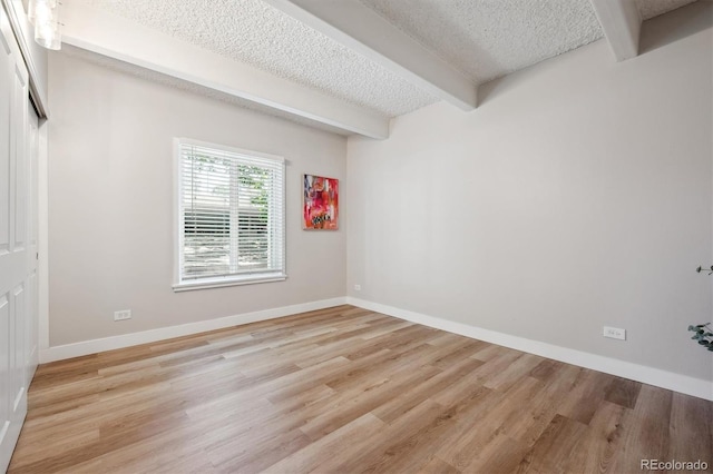 9700 E Iliff Ave Unit A3, Denver, CO 80231 - spare room with beam ceiling, a textured ceiling, and light wood-type flooring
