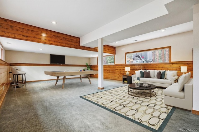 living room with wooden walls, recessed lighting, and carpet floors