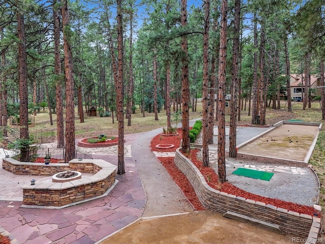 view of property's community featuring a bocce ball area and a fire pit