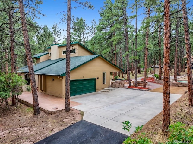 view of home's exterior featuring asphalt driveway, roof with shingles, and a garage