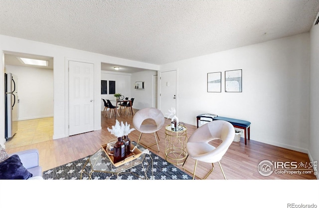 living area with a textured ceiling and wood finished floors