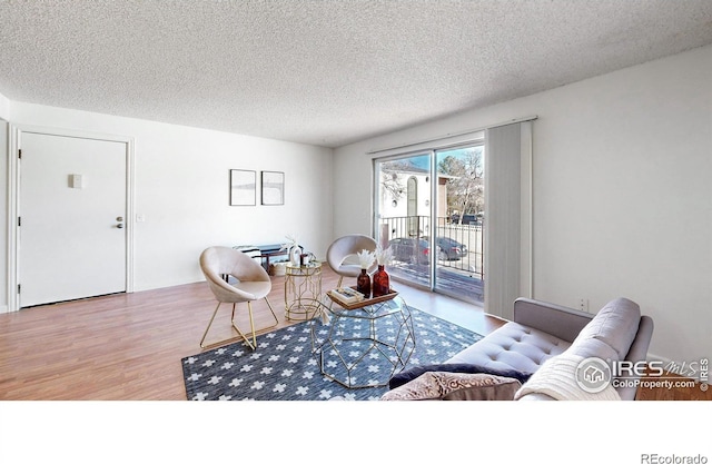 living area with a textured ceiling and wood finished floors