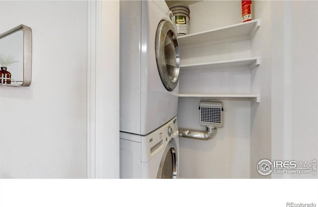 washroom featuring stacked washer / dryer and laundry area