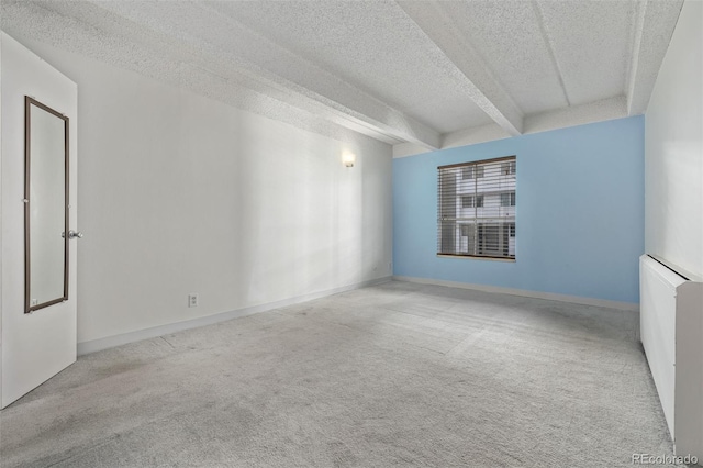 carpeted spare room featuring beam ceiling and a textured ceiling