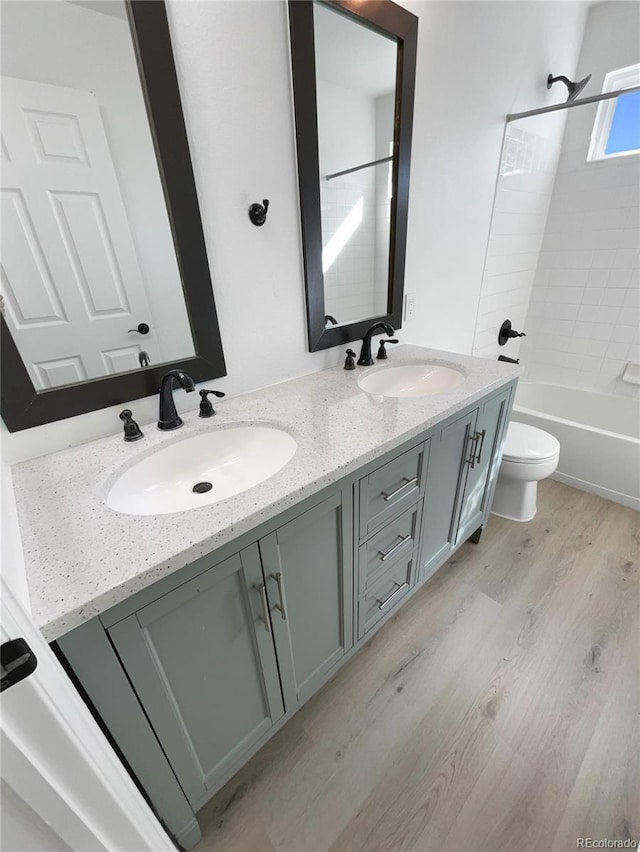 4735 S Cathay Ct, Aurora, CO 80015 - full bathroom featuring wood finished floors, double vanity, and bathing tub / shower combination