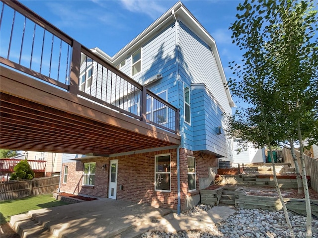 4735 S Cathay Ct, Aurora, CO 80015 - back of property with a patio, brick siding, and a wooden deck