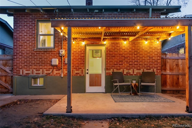 rear view of property featuring a pergola and a patio