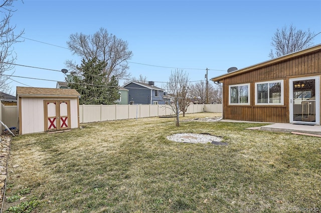 view of yard featuring a fenced backyard, a shed, and an outbuilding