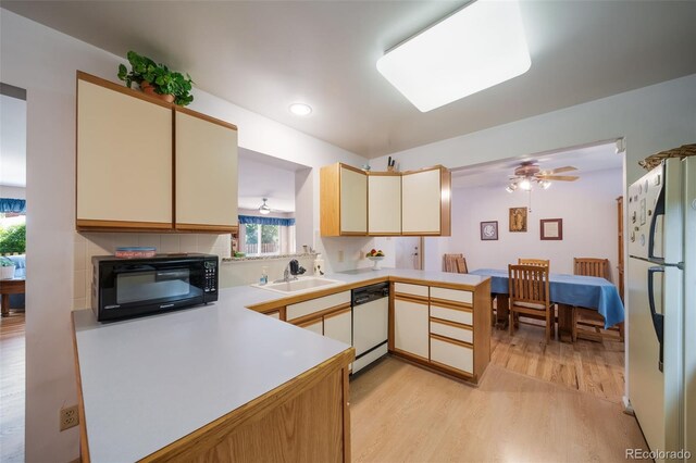 kitchen with white appliances, sink, cream cabinetry, light hardwood / wood-style floors, and kitchen peninsula