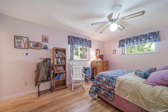 bedroom with multiple windows, ceiling fan, and light hardwood / wood-style flooring