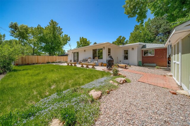 rear view of house with a yard and a patio