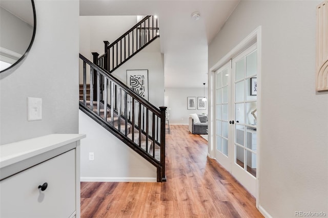 stairway with wood-type flooring and french doors