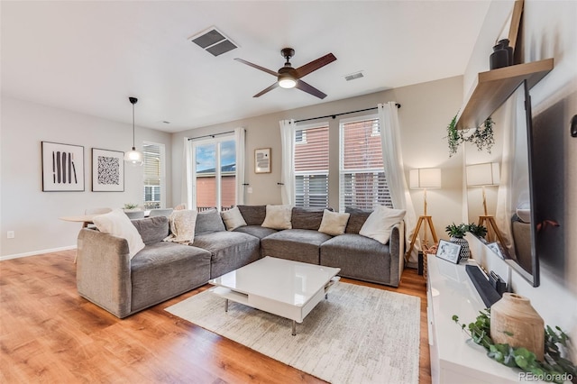 living room with ceiling fan and light wood-type flooring