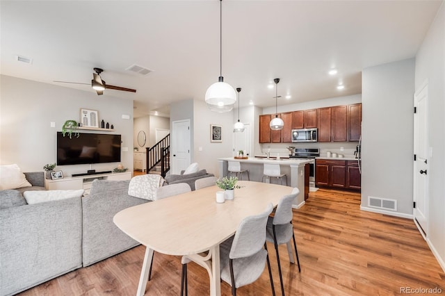 dining area with ceiling fan and light hardwood / wood-style flooring