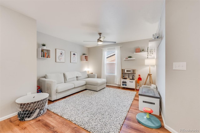 living room featuring wood-type flooring and ceiling fan