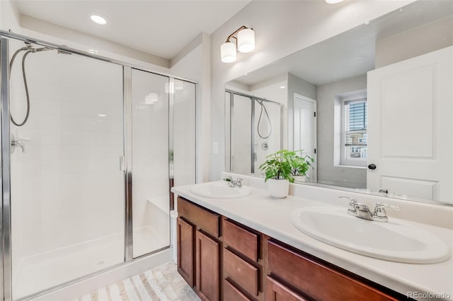 bathroom with vanity and a shower with door