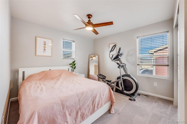 carpeted bedroom featuring multiple windows and ceiling fan