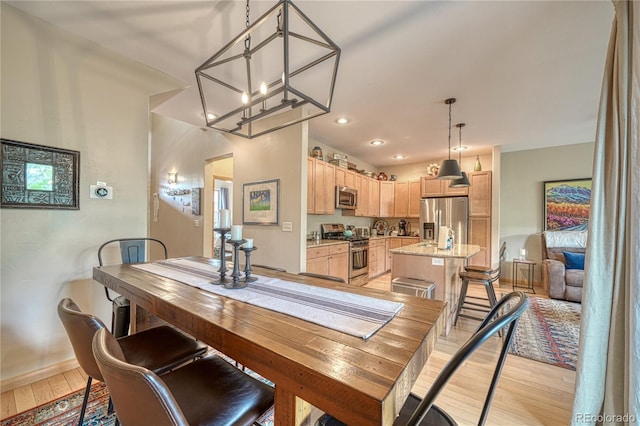 dining space with a notable chandelier, recessed lighting, baseboards, and light wood-style floors