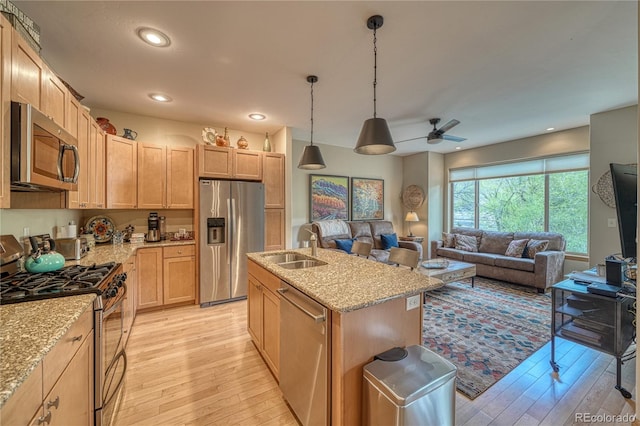 kitchen featuring open floor plan, light wood-style floors, appliances with stainless steel finishes, and ceiling fan