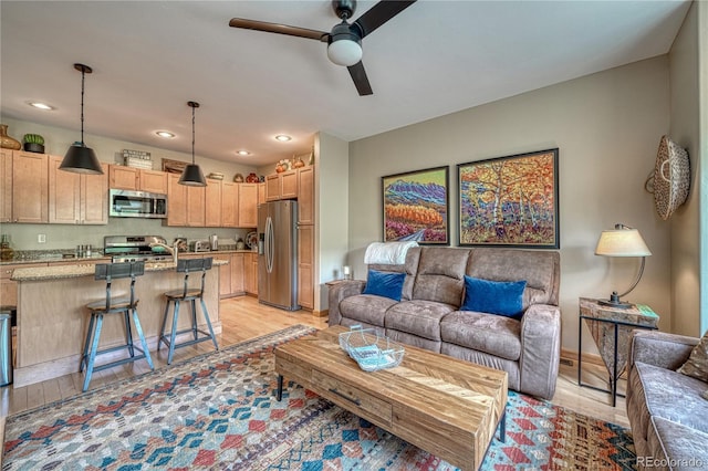 living room with light wood finished floors, recessed lighting, and a ceiling fan