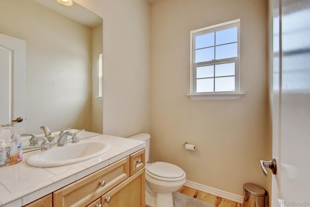 1864 Malibu Ct, Fort Lupton, CO 80621 - bathroom with toilet, vanity, baseboards, and wood finished floors