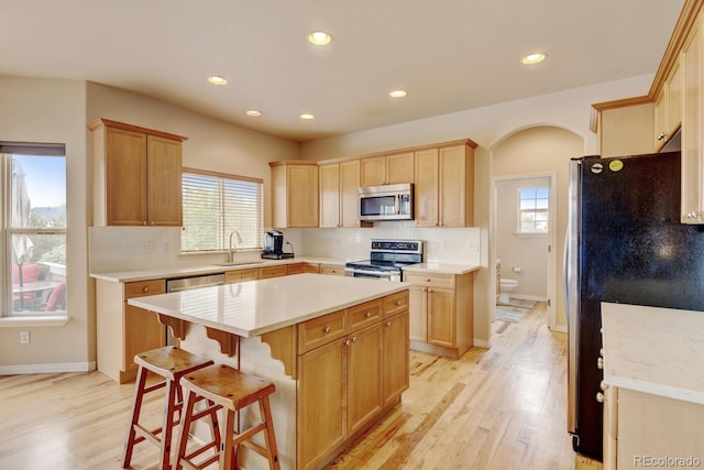 1864 Malibu Ct, Fort Lupton, CO 80621 - kitchen with stainless steel appliances, recessed lighting, tasteful backsplash, light wood-style flooring, and a kitchen island