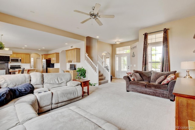 1864 Malibu Ct, Fort Lupton, CO 80621 - living area with stairs, light carpet, arched walkways, ceiling fan, and recessed lighting