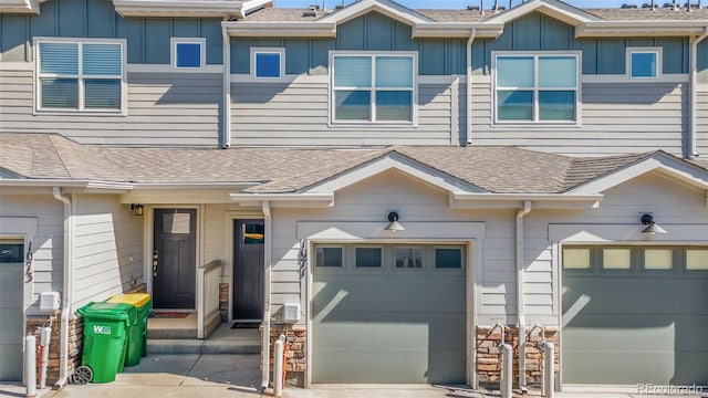 townhome / multi-family property with concrete driveway, an attached garage, board and batten siding, and a shingled roof