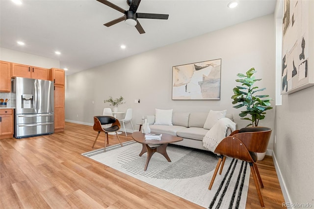 living area with recessed lighting, light wood-style flooring, a ceiling fan, and baseboards