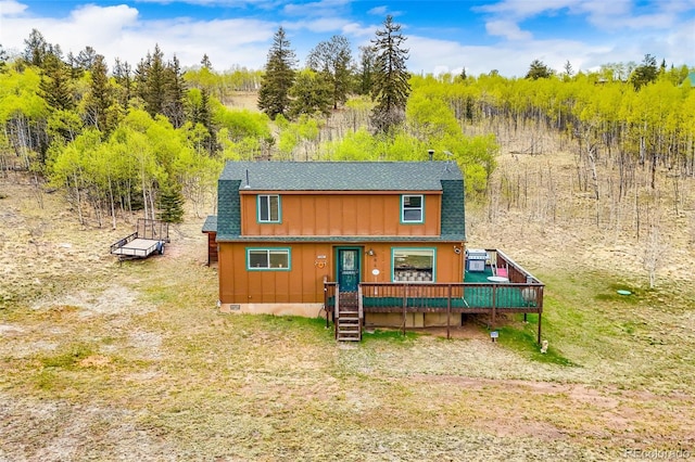 584 Old Squaw Rd, Como, CO 80432 - view of front facade featuring a wooden deck, a shingled roof, board and batten siding, and a front lawn