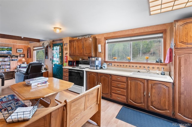584 Old Squaw Rd, Como, CO 80432 - kitchen featuring white range with electric stovetop, stainless steel microwave, light countertops, light wood-type flooring, and brown cabinets