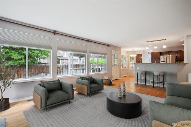 5721 S Jellison St, Littleton, CO 80123 - living area with light wood-style floors and a chandelier