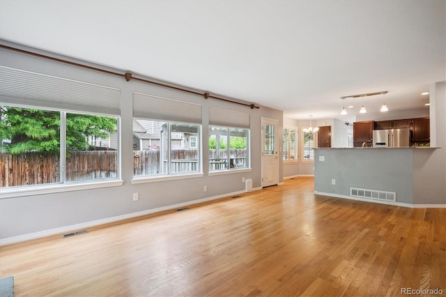 5721 S Jellison St, Littleton, CO 80123 - unfurnished living room with light wood finished floors and a chandelier
