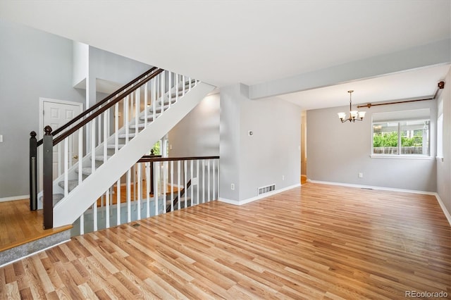 5721 S Jellison St, Littleton, CO 80123 - unfurnished living room with wood finished floors, a chandelier, and stairway