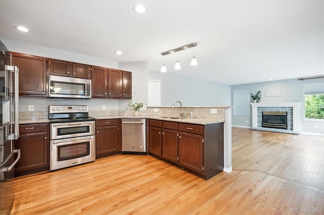 5721 S Jellison St, Littleton, CO 80123 - kitchen featuring appliances with stainless steel finishes, a peninsula, light wood-style flooring, open floor plan, and recessed lighting