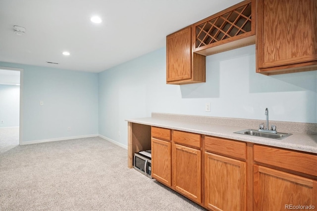 5721 S Jellison St, Littleton, CO 80123 - kitchen with light colored carpet, recessed lighting, light countertops, and brown cabinetry