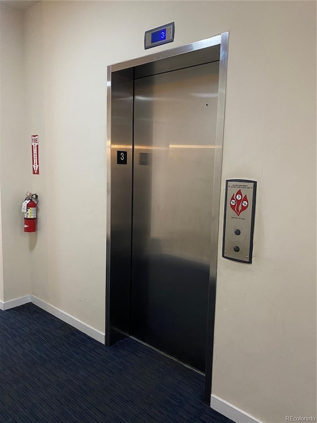 336 E 1st Ave Unit 310, Denver, CO 80203 - hall featuring elevator, baseboards, and dark colored carpet
