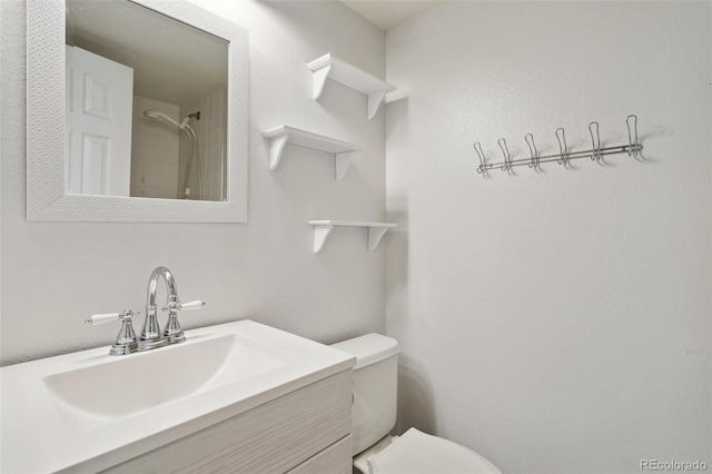 bathroom featuring vanity, toilet, and a shower