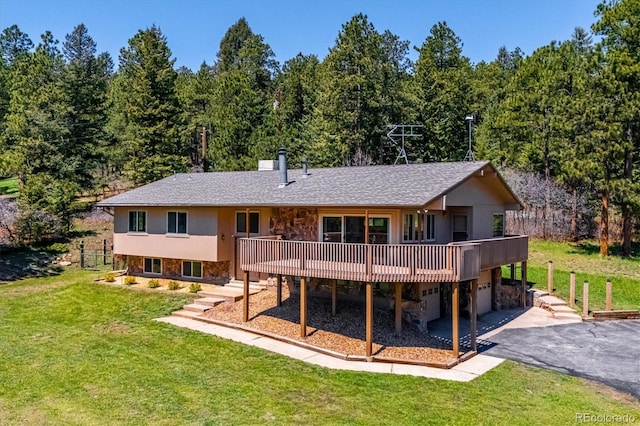 8045 S Wagon Wheel Rd, Morrison, CO 80465 - back of house featuring asphalt driveway, an attached garage, a lawn, and a deck