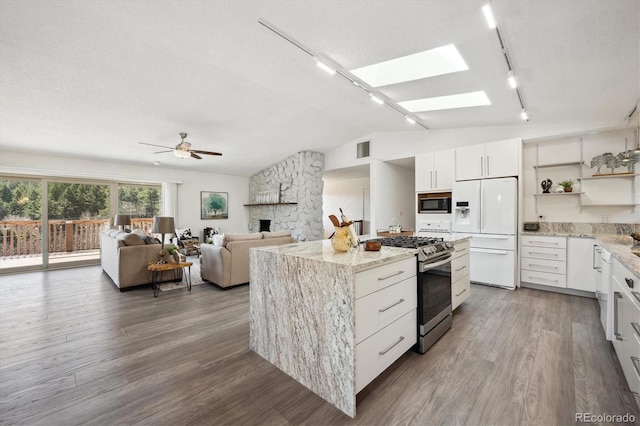 8045 S Wagon Wheel Rd, Morrison, CO 80465 - kitchen with white fridge with ice dispenser, rail lighting, stainless steel gas range oven, vaulted ceiling, and a ceiling fan