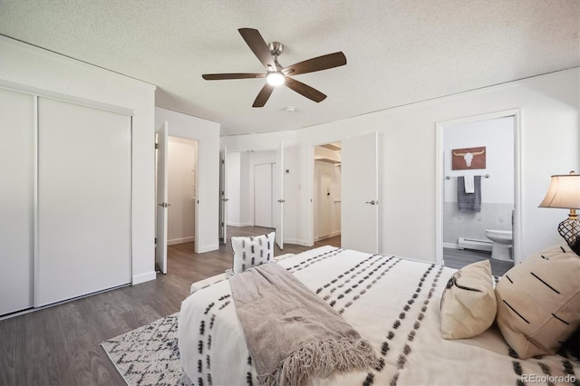 8045 S Wagon Wheel Rd, Morrison, CO 80465 - bedroom featuring wood finished floors, a textured ceiling, a closet, ensuite bathroom, and baseboard heating