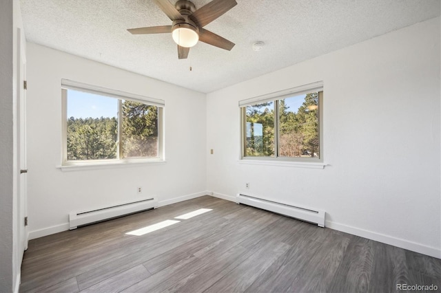 8045 S Wagon Wheel Rd, Morrison, CO 80465 - unfurnished room with a baseboard heating unit, plenty of natural light, a textured ceiling, and wood finished floors