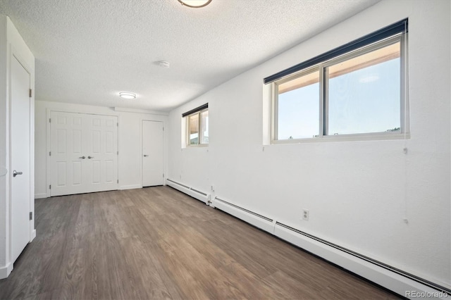 8045 S Wagon Wheel Rd, Morrison, CO 80465 - spare room featuring a baseboard heating unit, wood finished floors, and a textured ceiling