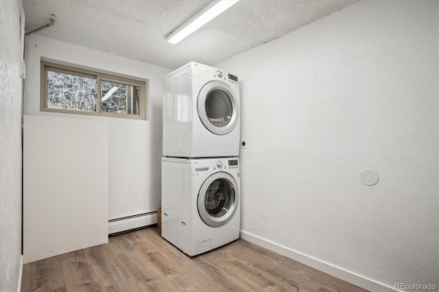 8045 S Wagon Wheel Rd, Morrison, CO 80465 - washroom with stacked washer / drying machine, a baseboard heating unit, wood finished floors, a textured wall, and a textured ceiling