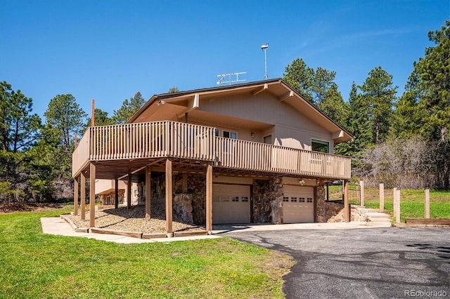 8045 S Wagon Wheel Rd, Morrison, CO 80465 - back of property featuring a deck, a garage, a yard, driveway, and stone siding