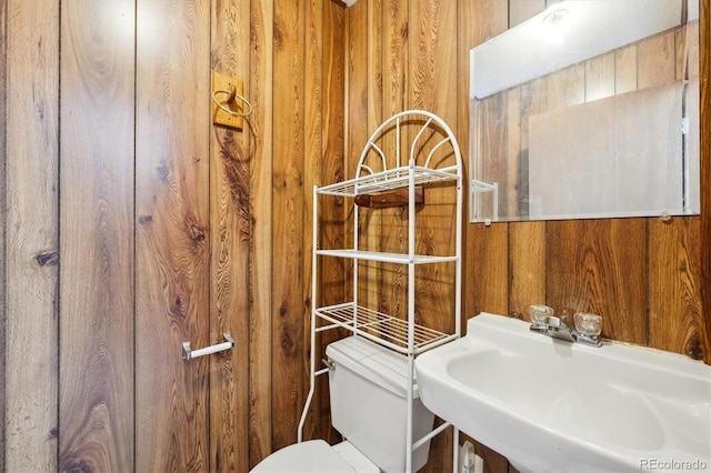 8045 S Wagon Wheel Rd, Morrison, CO 80465 - bathroom featuring a sink, wooden walls, and toilet