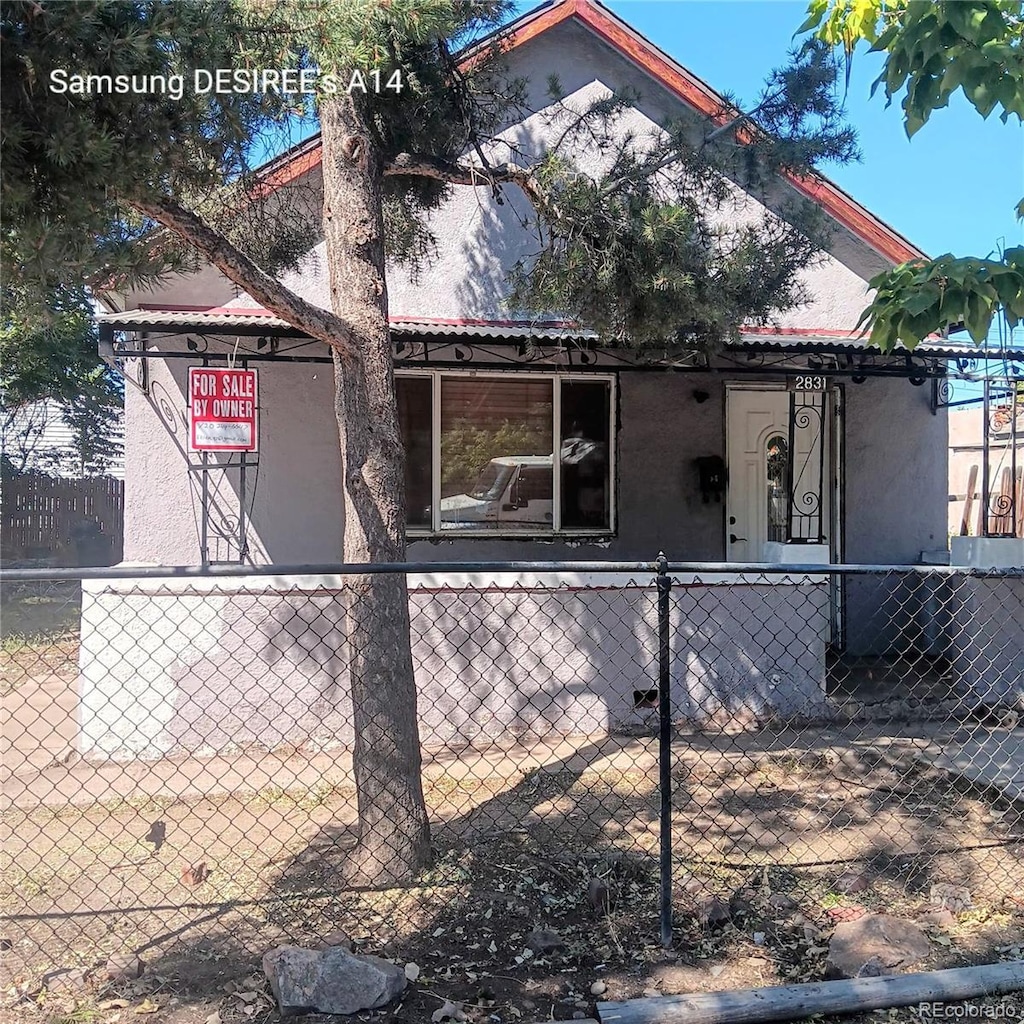 2831 Lawrence St, Denver, CO 80205 - view of side of property featuring stucco siding and a fenced front yard